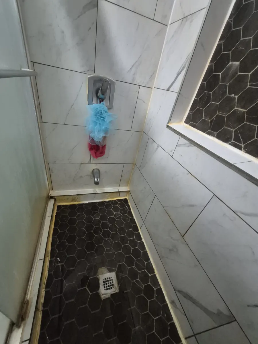 Yellow stained shower deep cleaning before photo